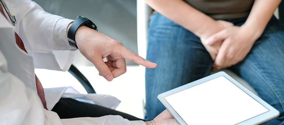 Médico-con-una-tableta-digital-habla-y-explica-un-diagnóstico-a-un-paciente-varón