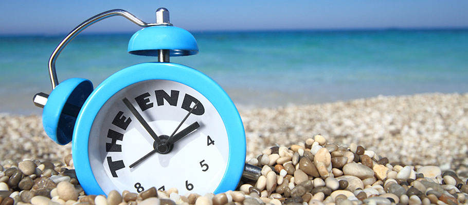 Reloj-sobre-arena-de-playa-marcando-el-final