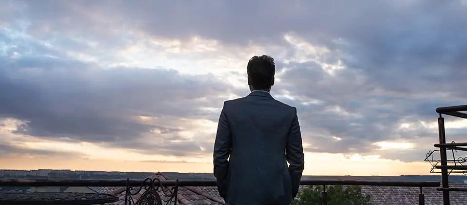 Hombre-de-pie-y-de-espaldas-mirando-las-vistas-de-una-ciudad