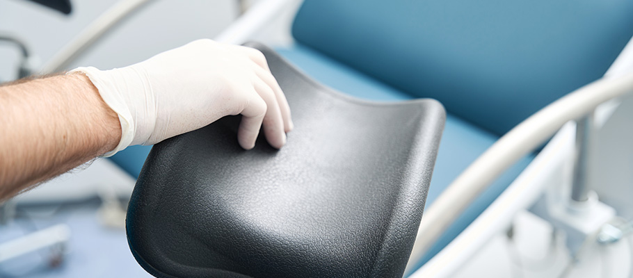 Mano-de-médico-en-el-reposapiés-de-una-silla-médica