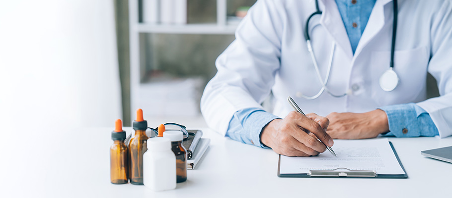 Médico en consulta apuntando información del paciente