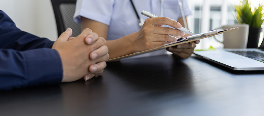 Manos de un paciente junto a las de un médico en consulta
