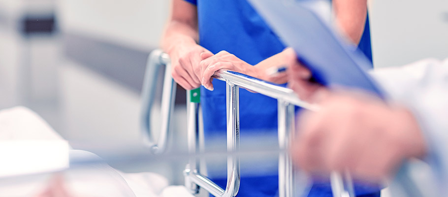 Manos-de-médico-agarrando-una-camilla-con-un-paciente